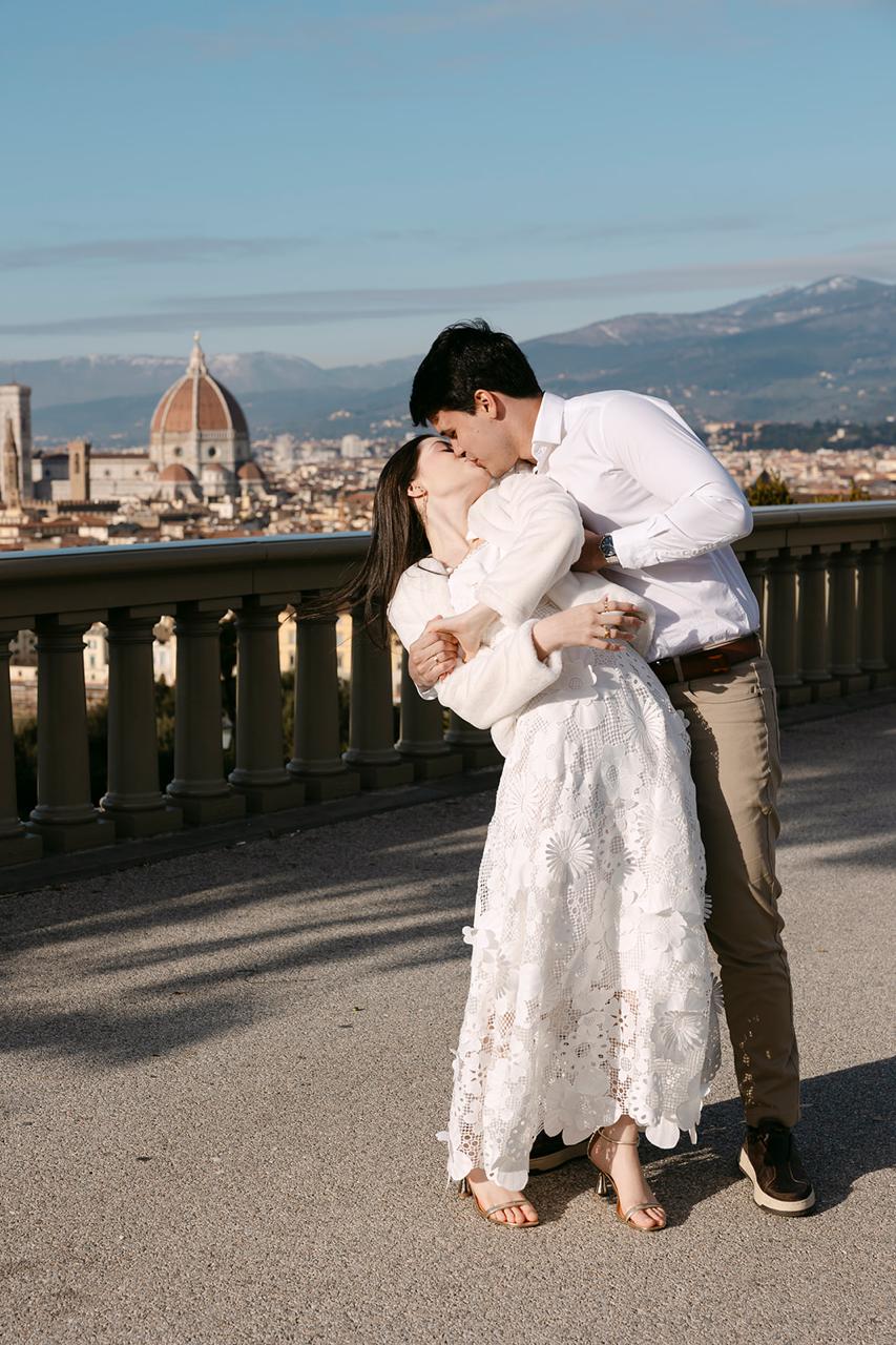 Lívia e André se beijando diante da paisagem de Florença
